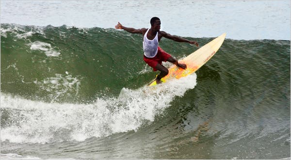 Robertsport beach Liberia with surfers and palm trees