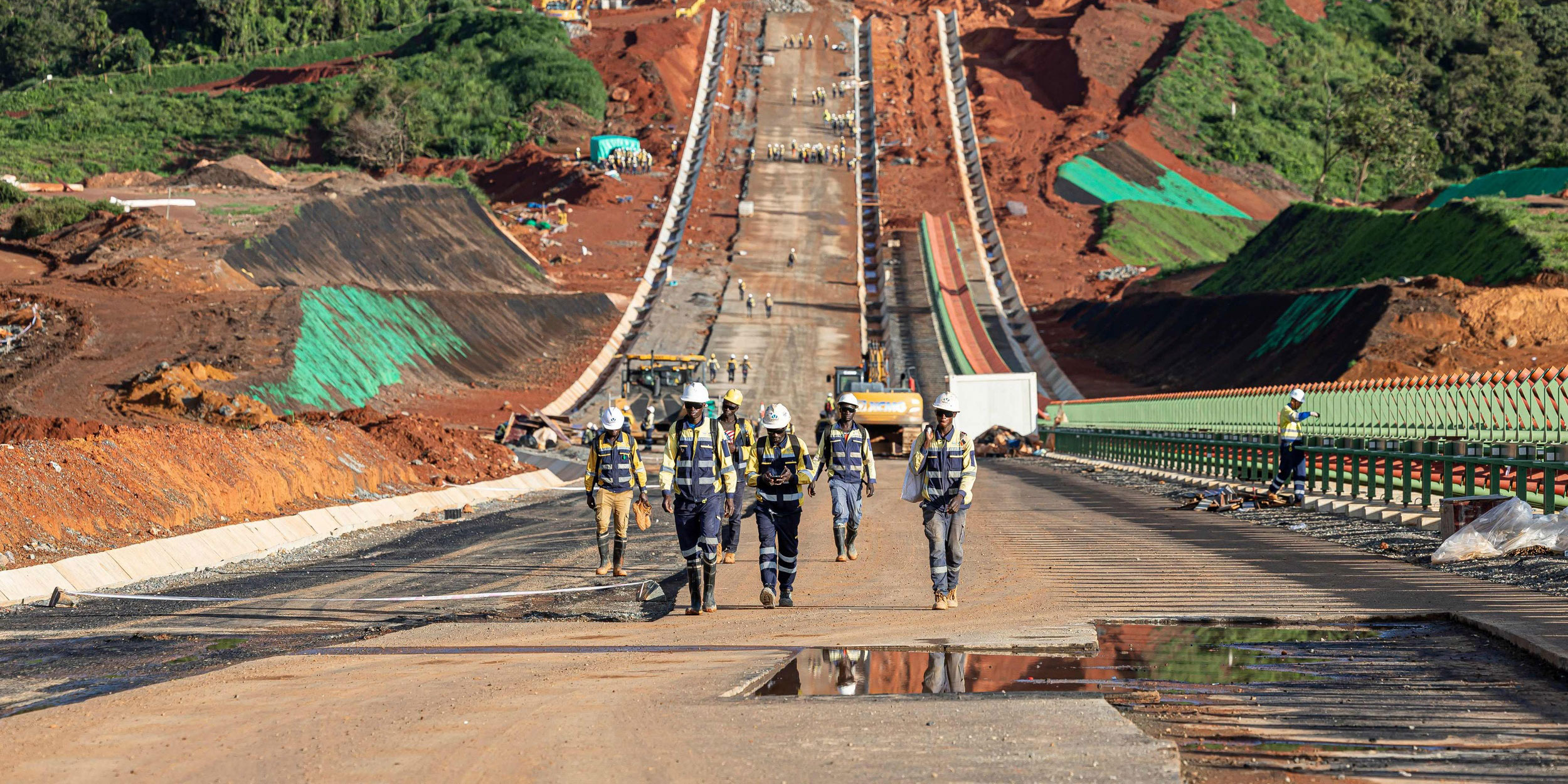Iron ore mining operation in West Africa with heavy machinery and rail transport