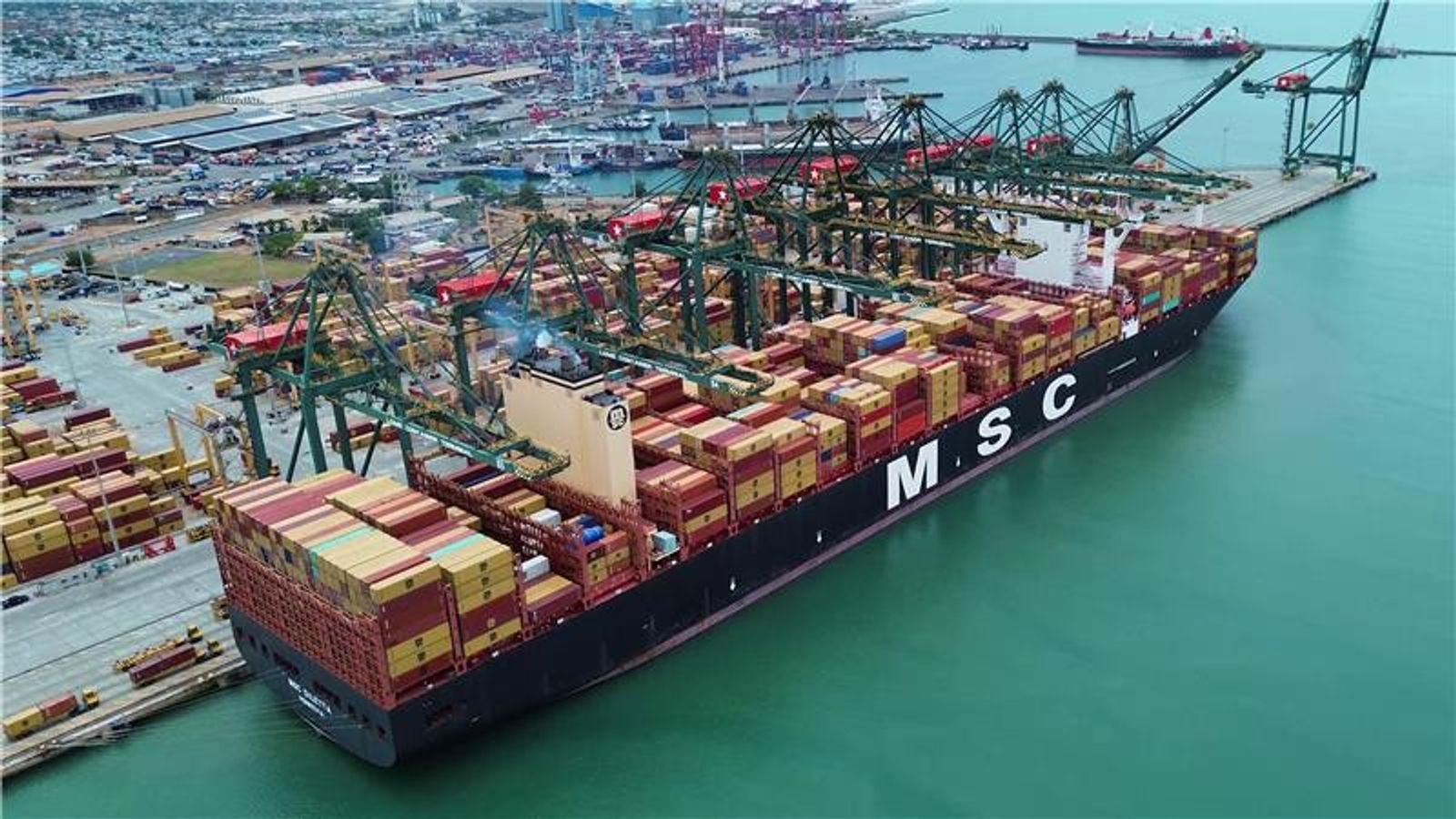 Large cargo ship at a West African port with shipping containers
