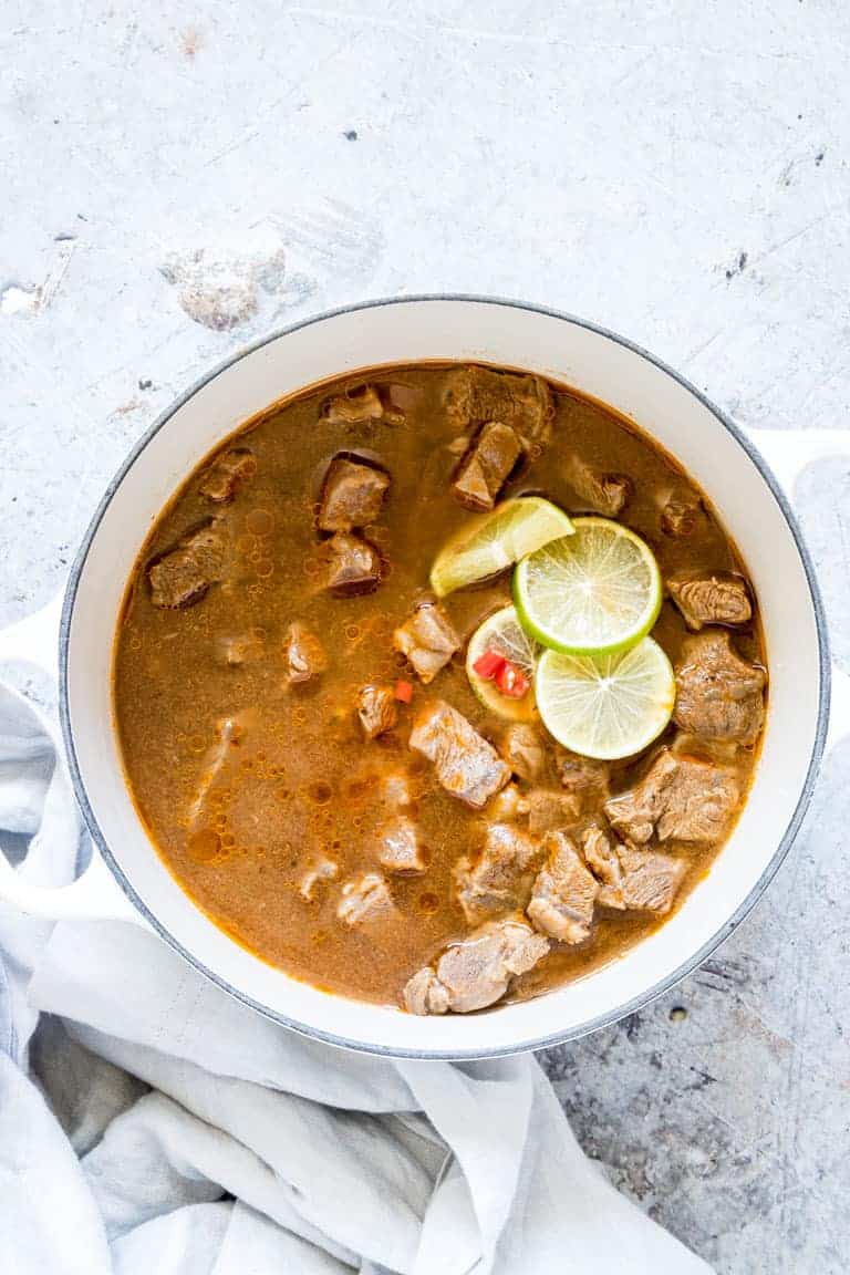 Traditional Liberian pepper soup served in a clay bowl with fresh herbs