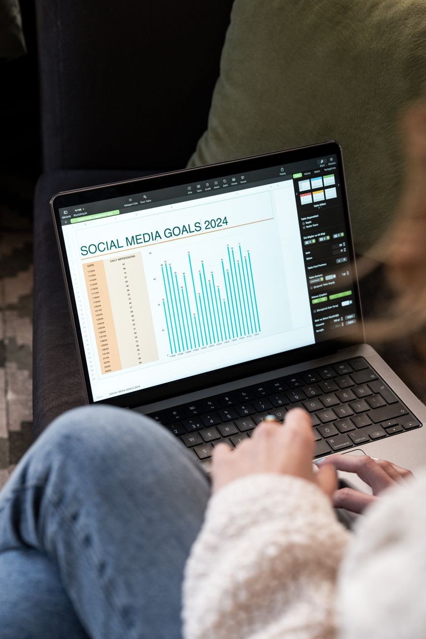 Creator using AI social media content tools on a laptop at a modern desk