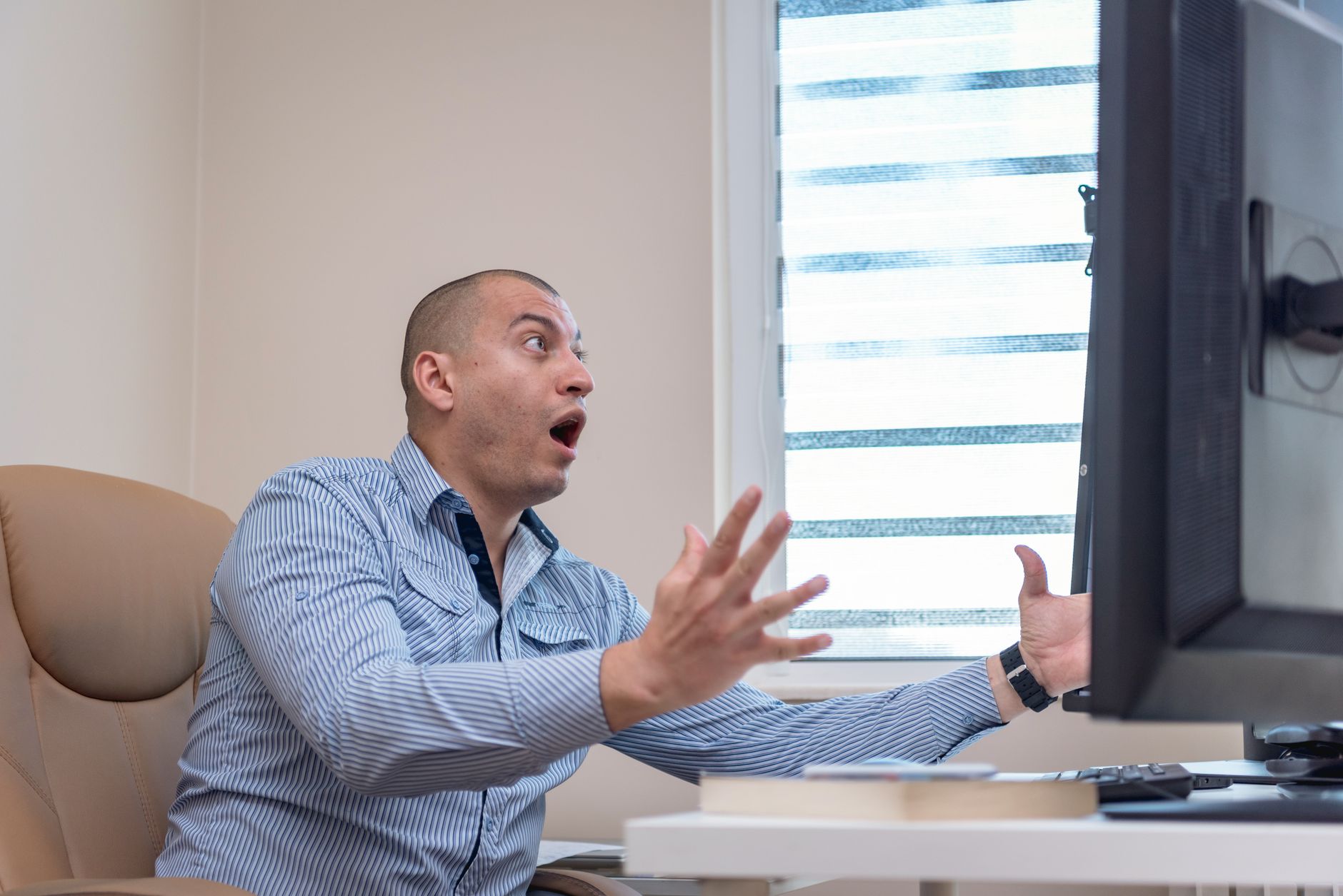 Person looking shocked at a computer screen showing an error