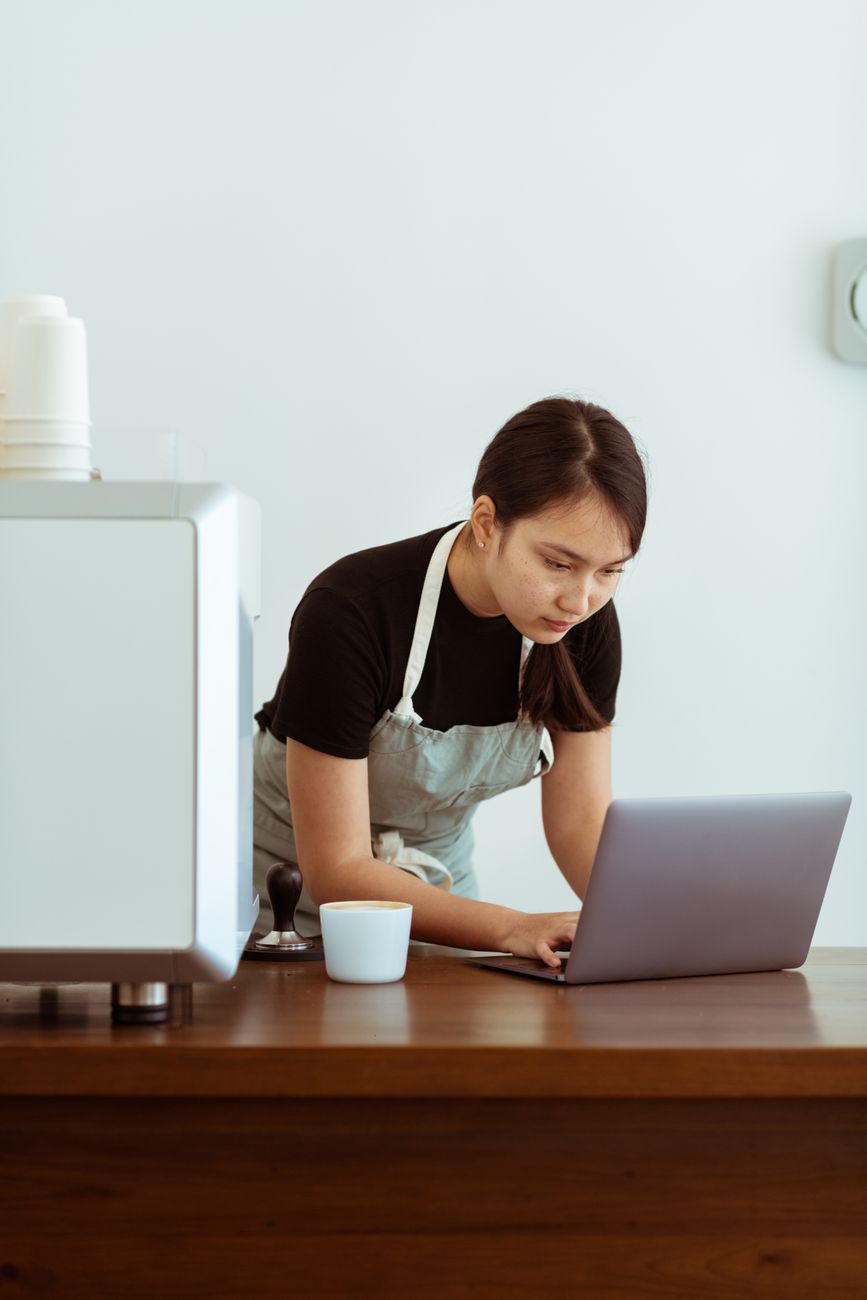 Small business owner managing social media on a laptop with AI dashboard