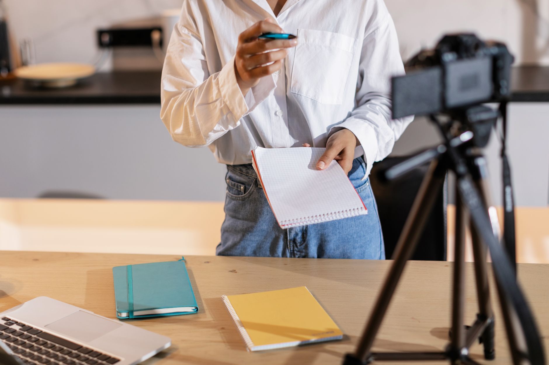 Content creator filming a TikTok video at a desk with a ring light and script notes