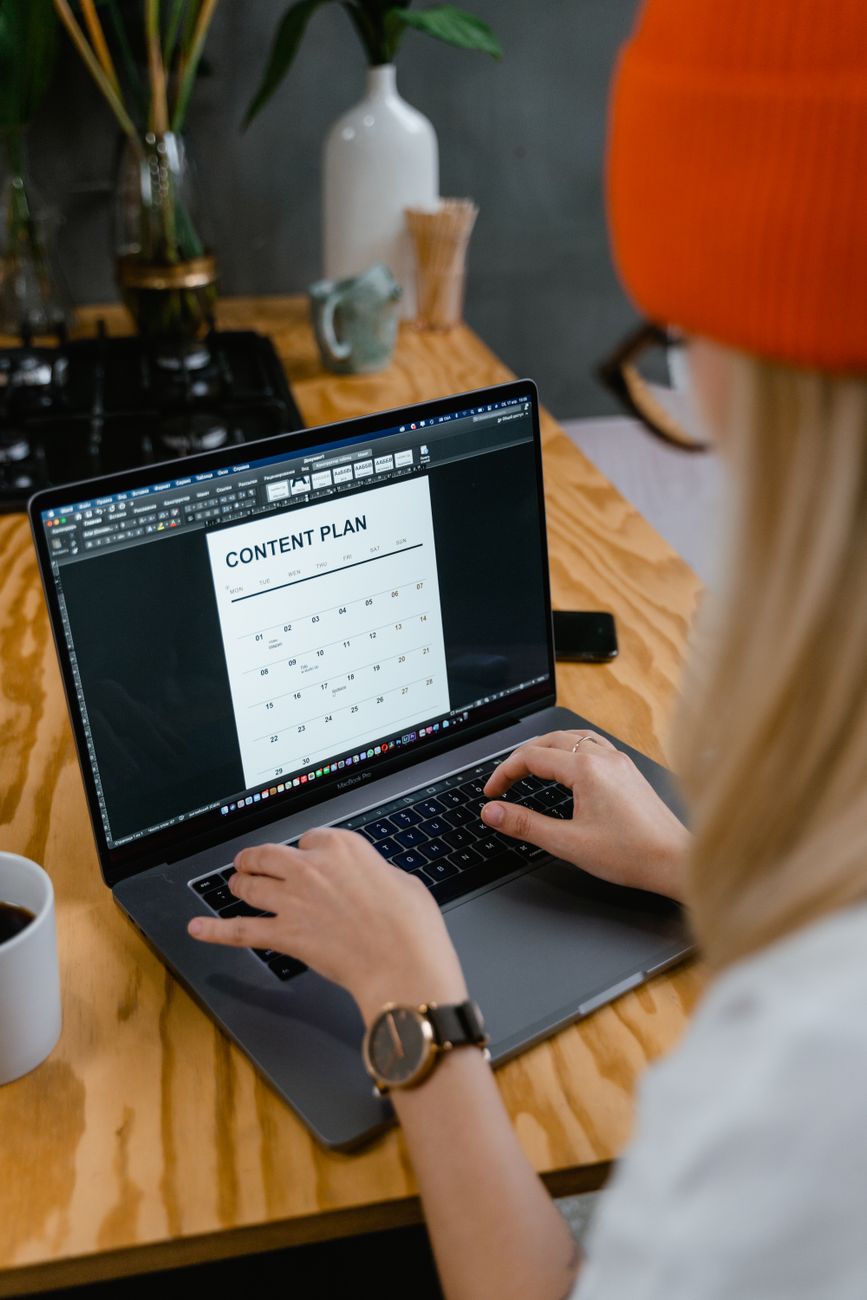 Social media content calendar on laptop screen with analytics dashboard