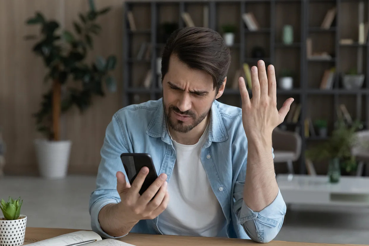 Creator frustrated looking at Instagram settings on smartphone
