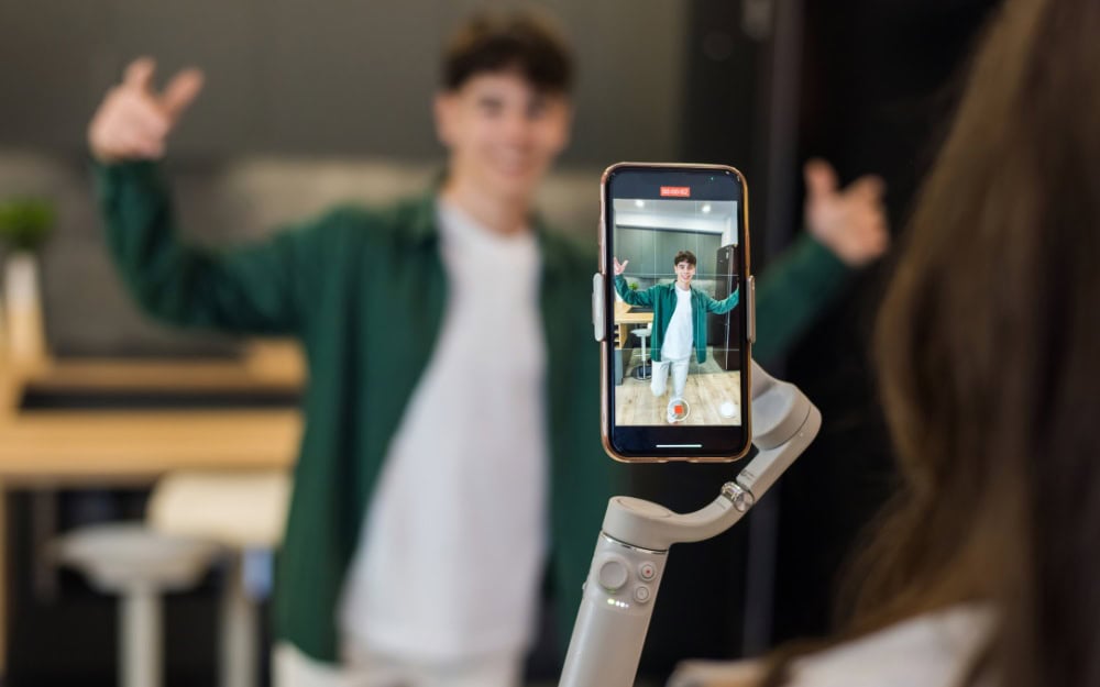 Creator filming a TikTok video with a ring light and smartphone
