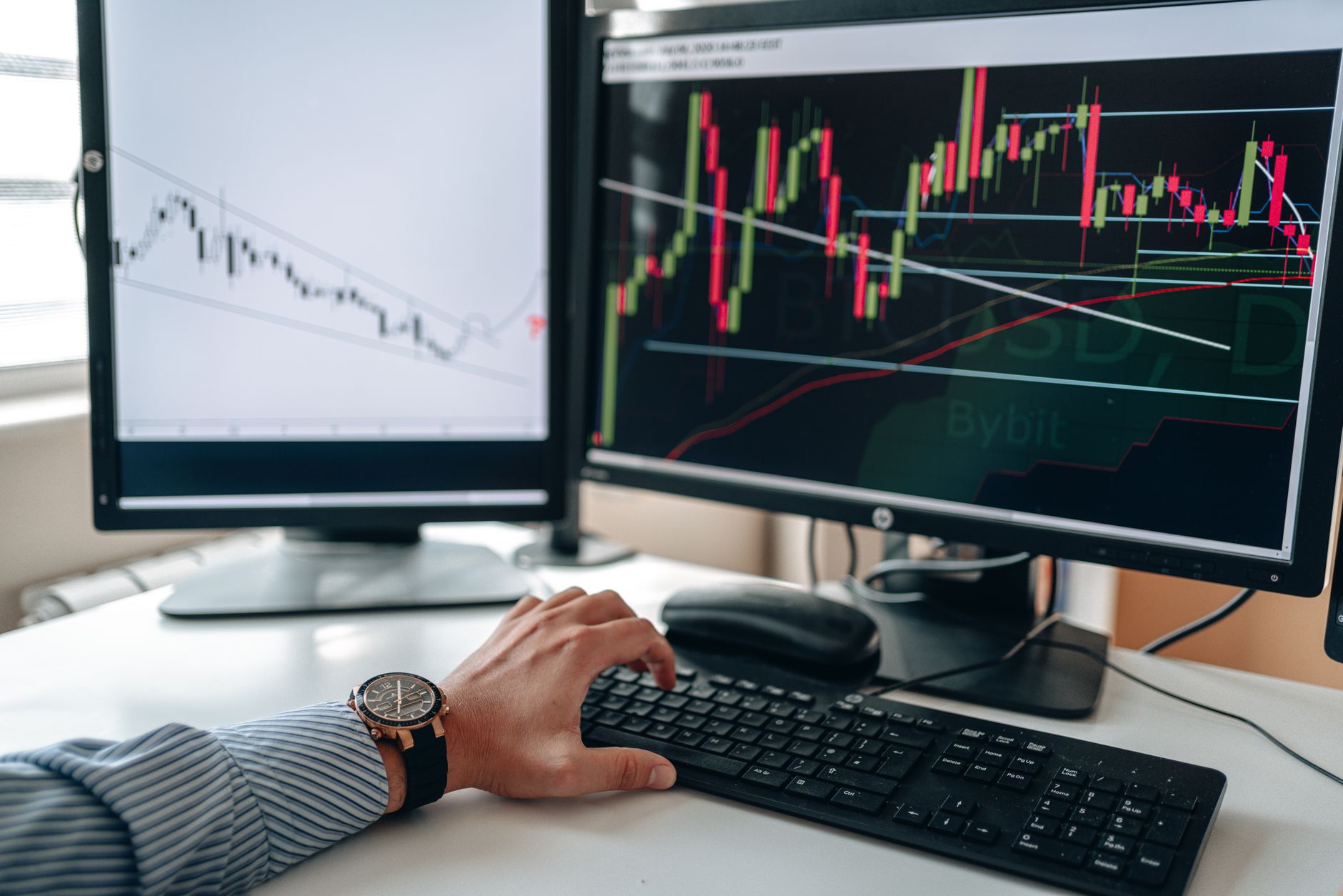 Digital marketer reviewing performance data on dual monitors in home office