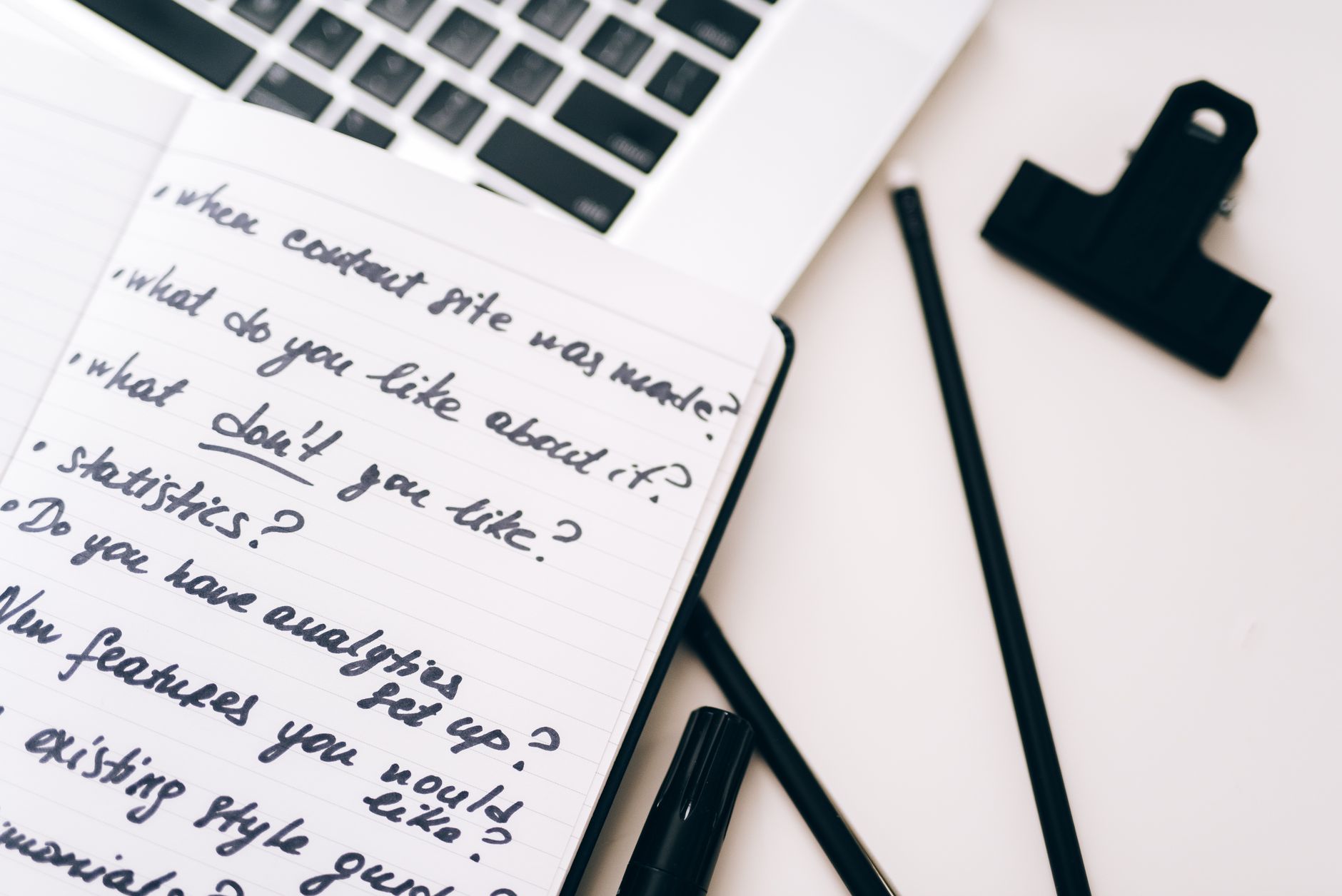 Content marketing plan written in a notebook with a laptop nearby