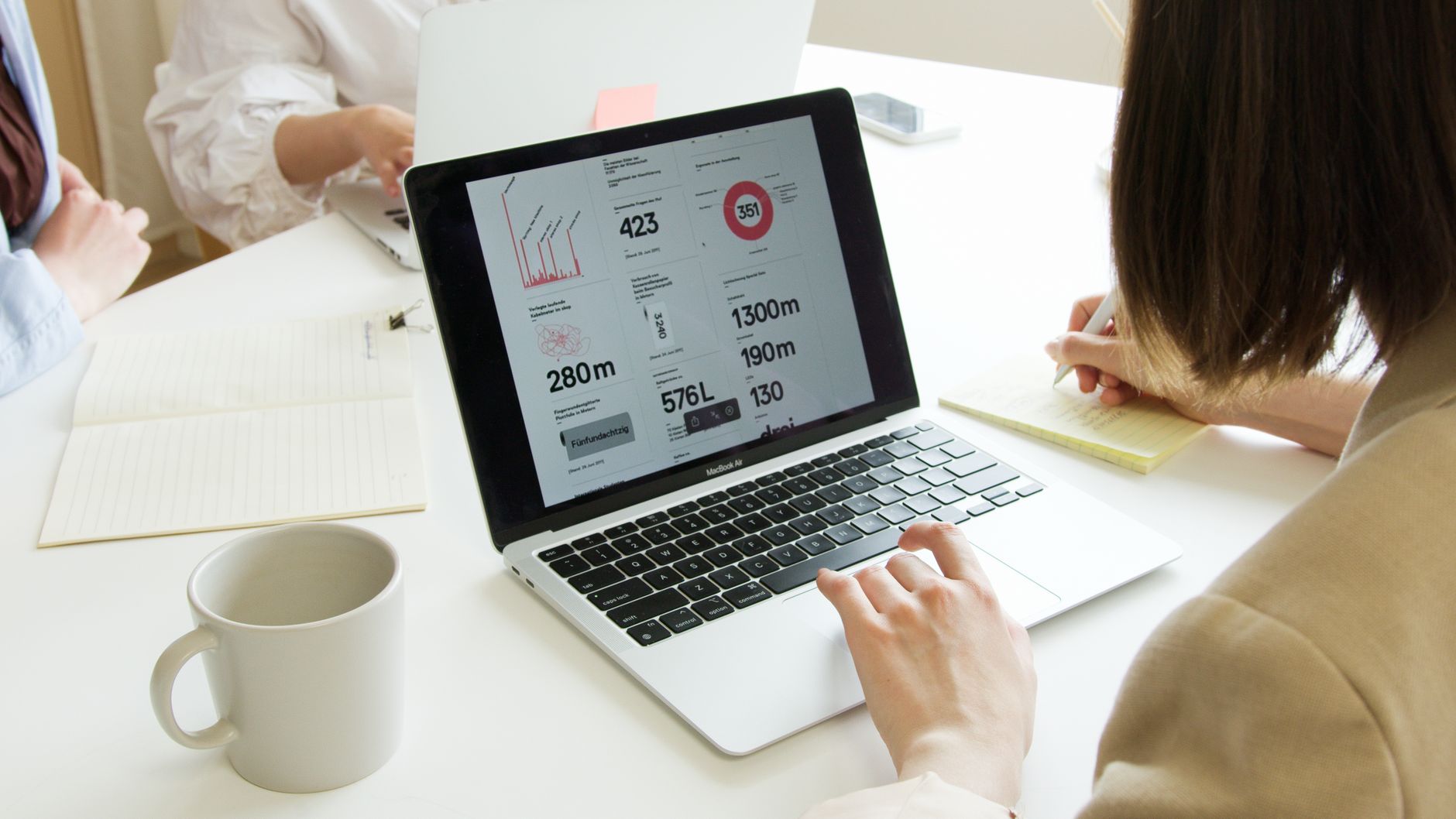 Person creating digital marketing content on a laptop with analytics dashboard visible