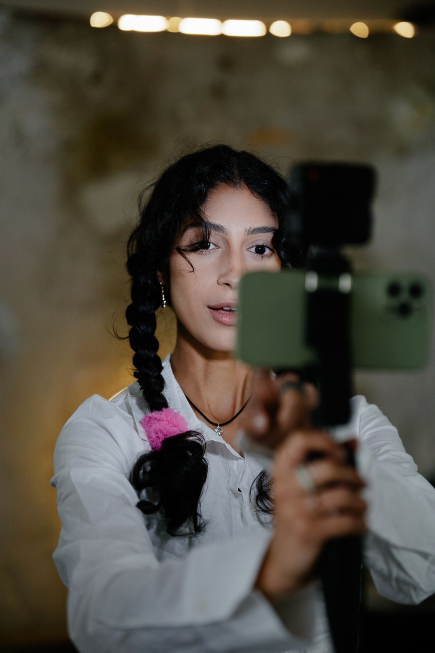 Content creator filming a marketing video with a smartphone and ring light