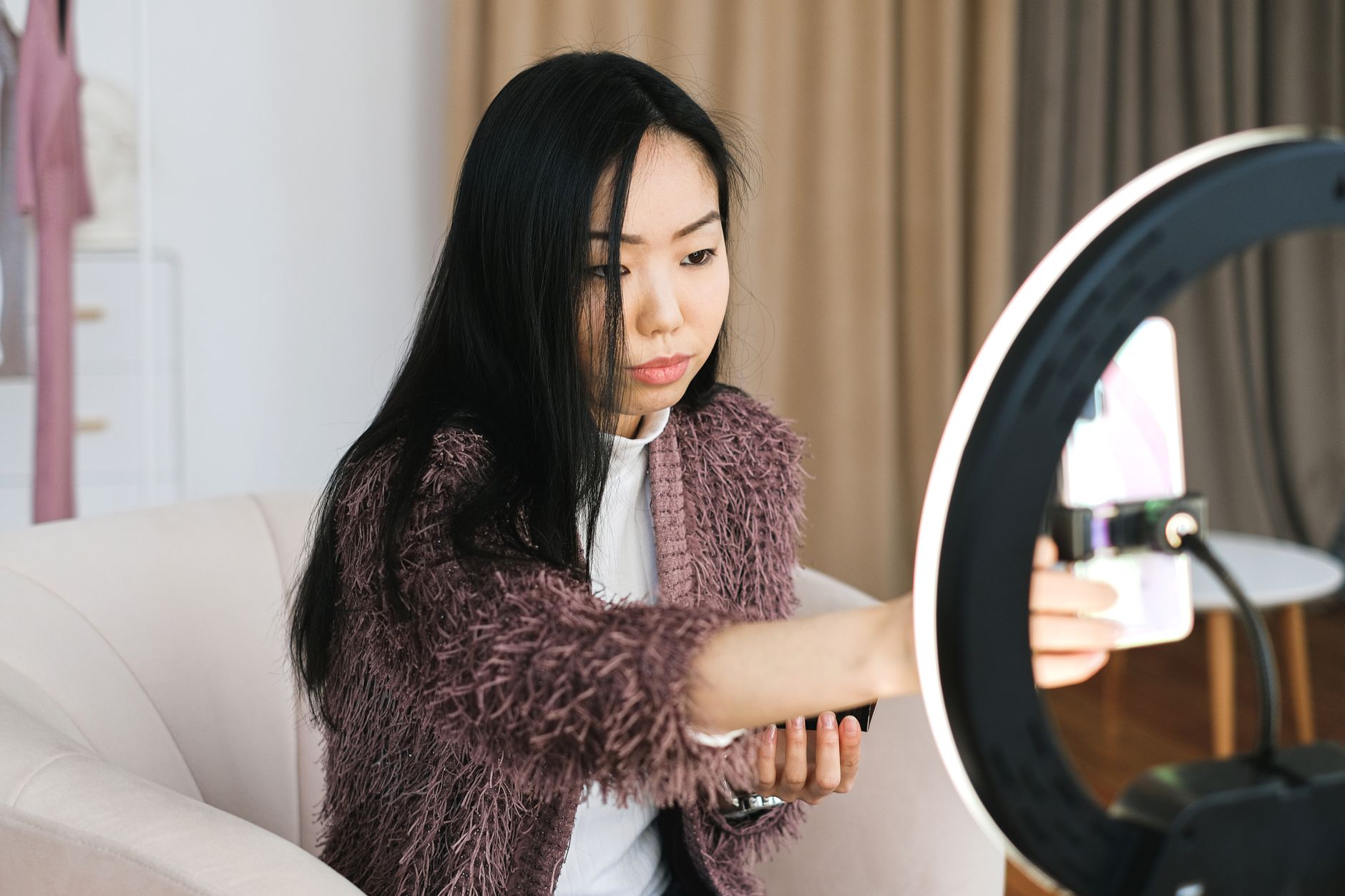 Creator filming a short form video on a smartphone with ring light setup