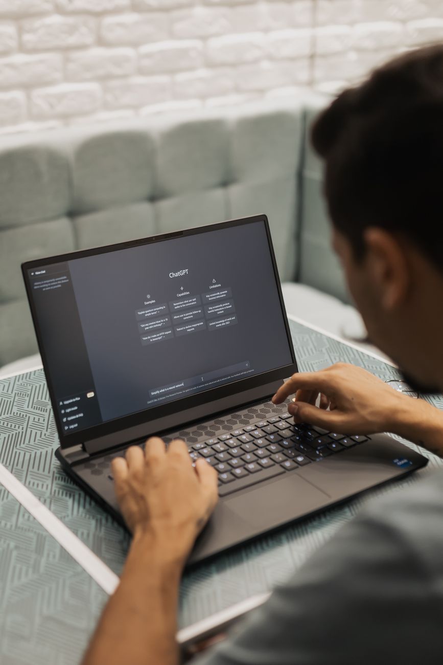 Person using laptop with AI chatbot and SEO dashboard side by side