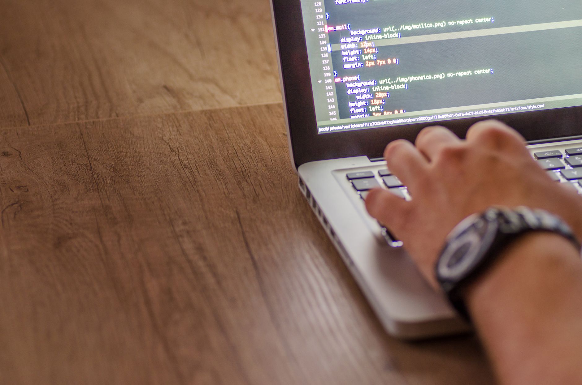 Developer fixing website code on a monitor showing technical errors