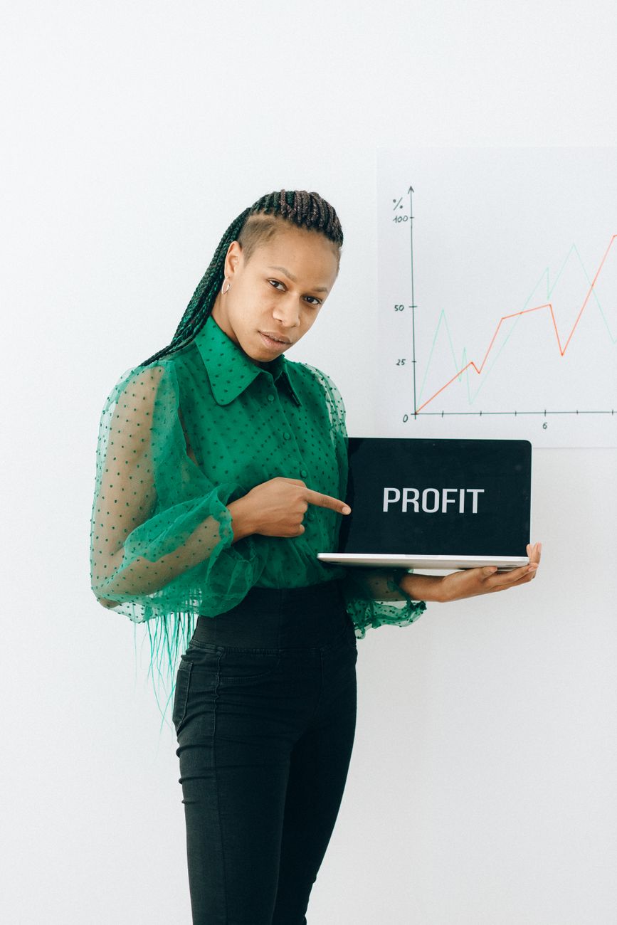 African digital creator working on laptop with investment charts on screen