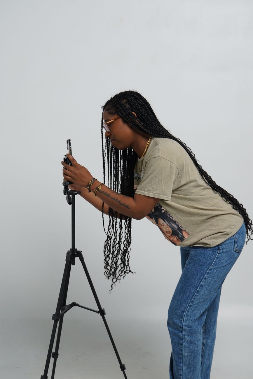 African creator recording content on smartphone in urban studio setting