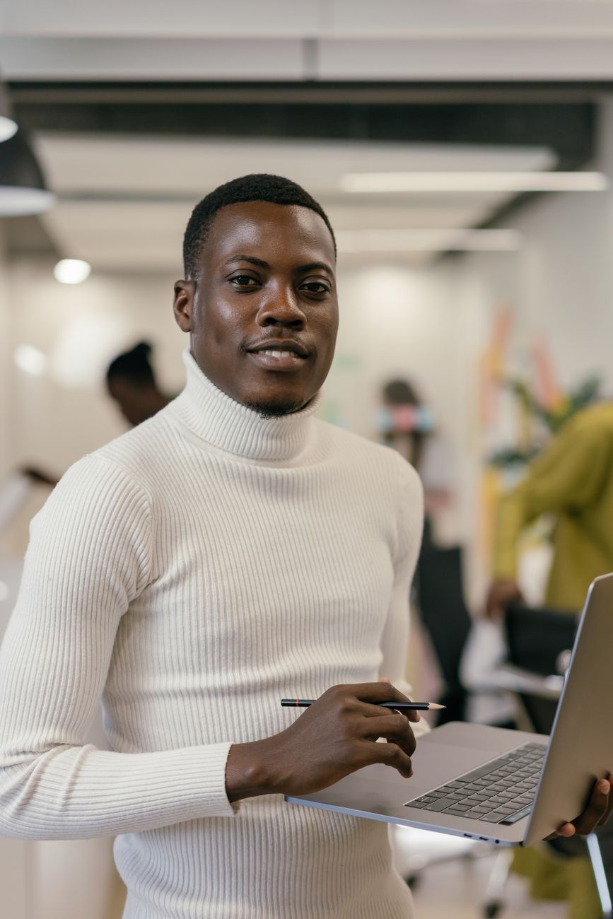 African entrepreneur working on laptop in modern co-working space