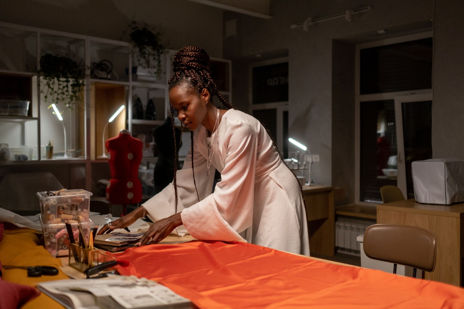 African fashion designer reviewing fabric samples in a bright studio