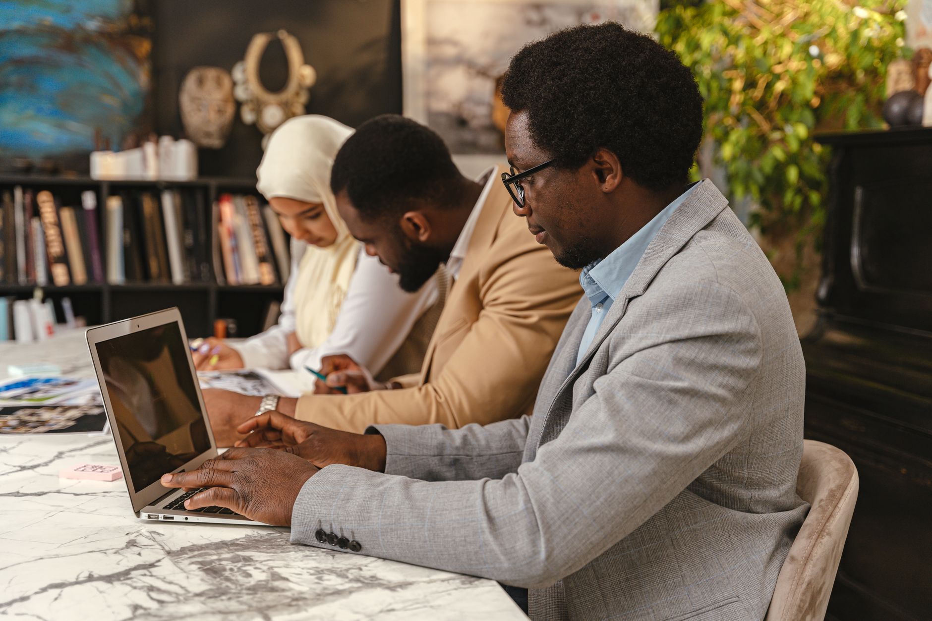 Group of young African digital creators collaborating on laptops in a co-working space