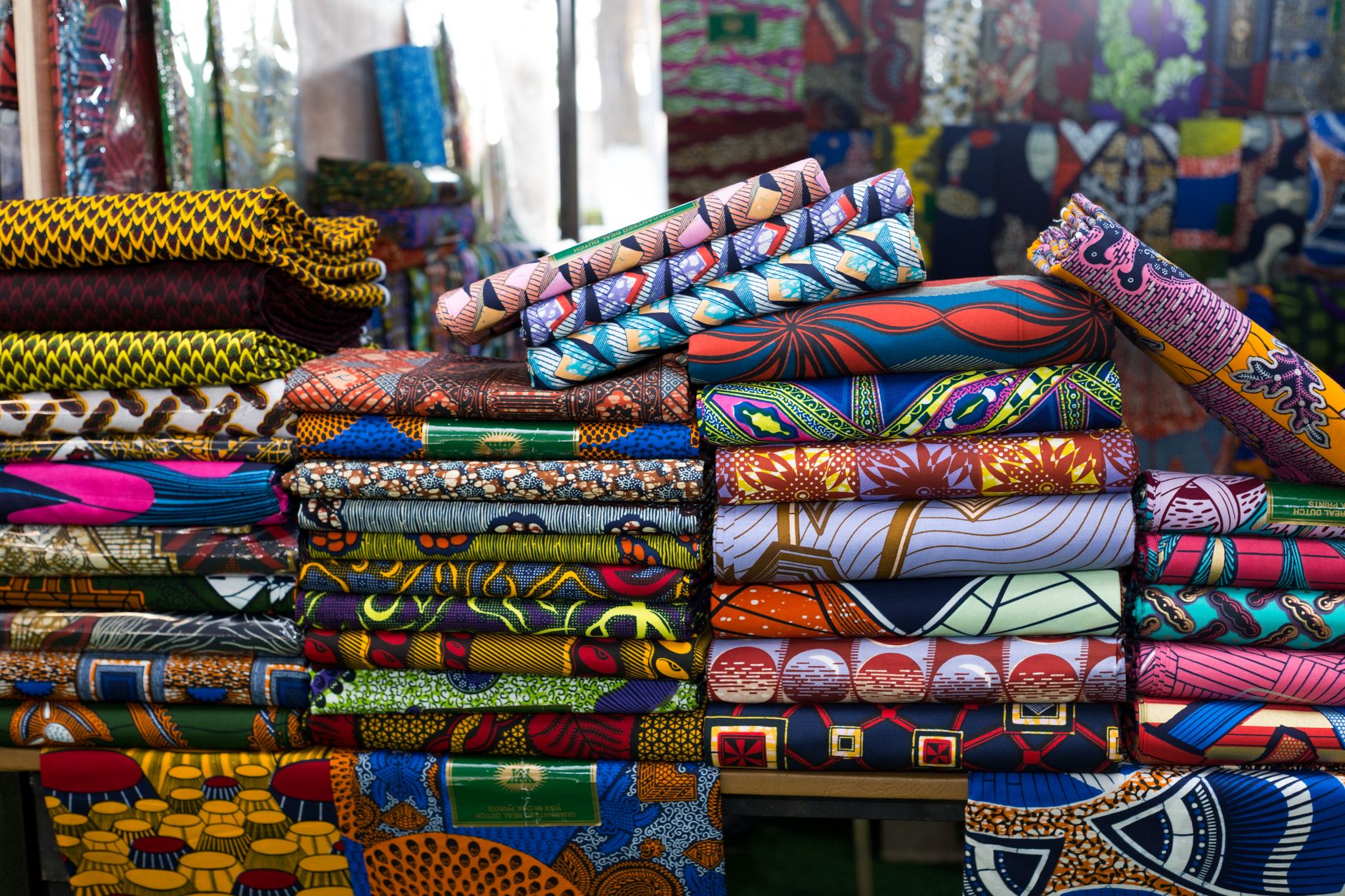 African fashion designer working on traditional fabric patterns in a modern studio