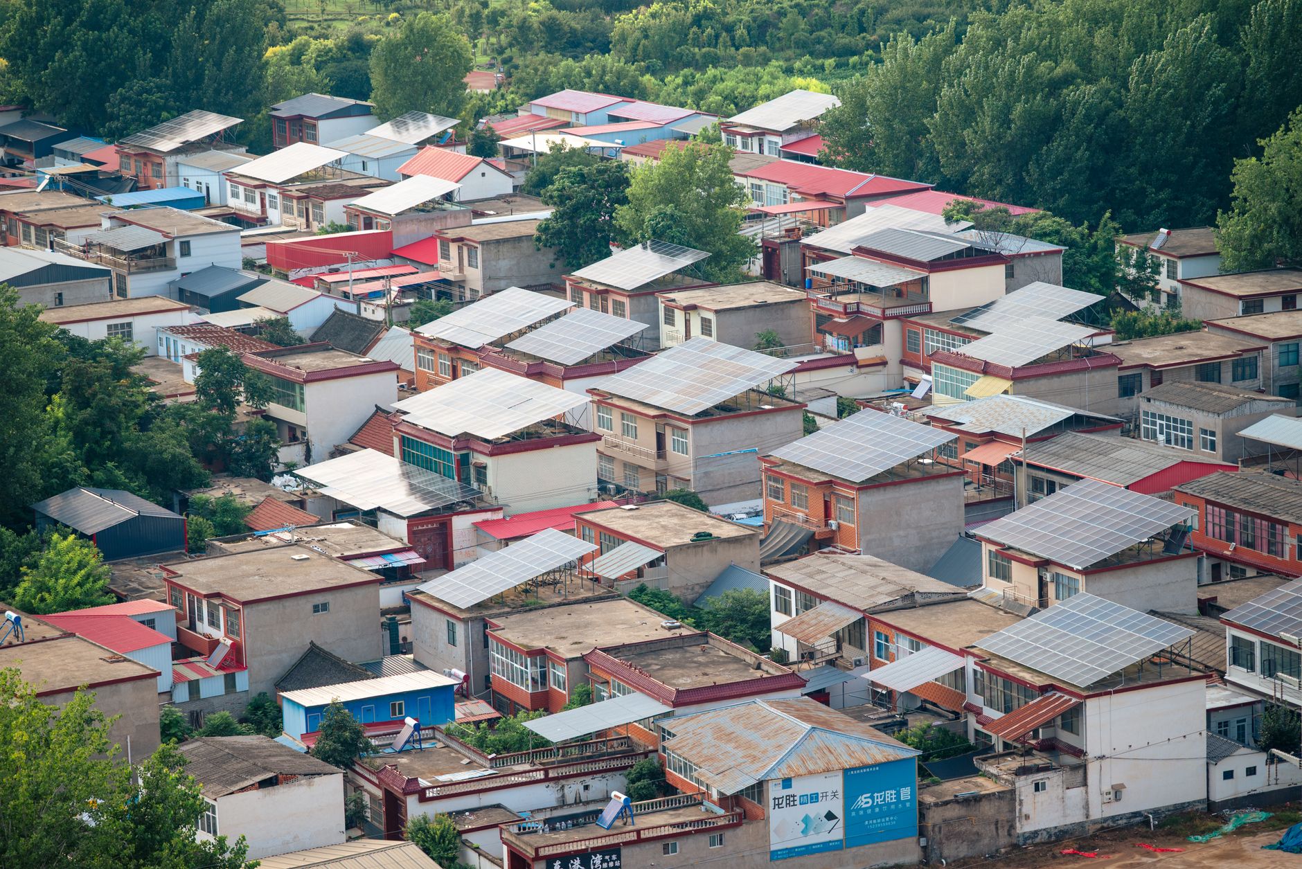 Solar panels installed on a rural African home with community members nearby