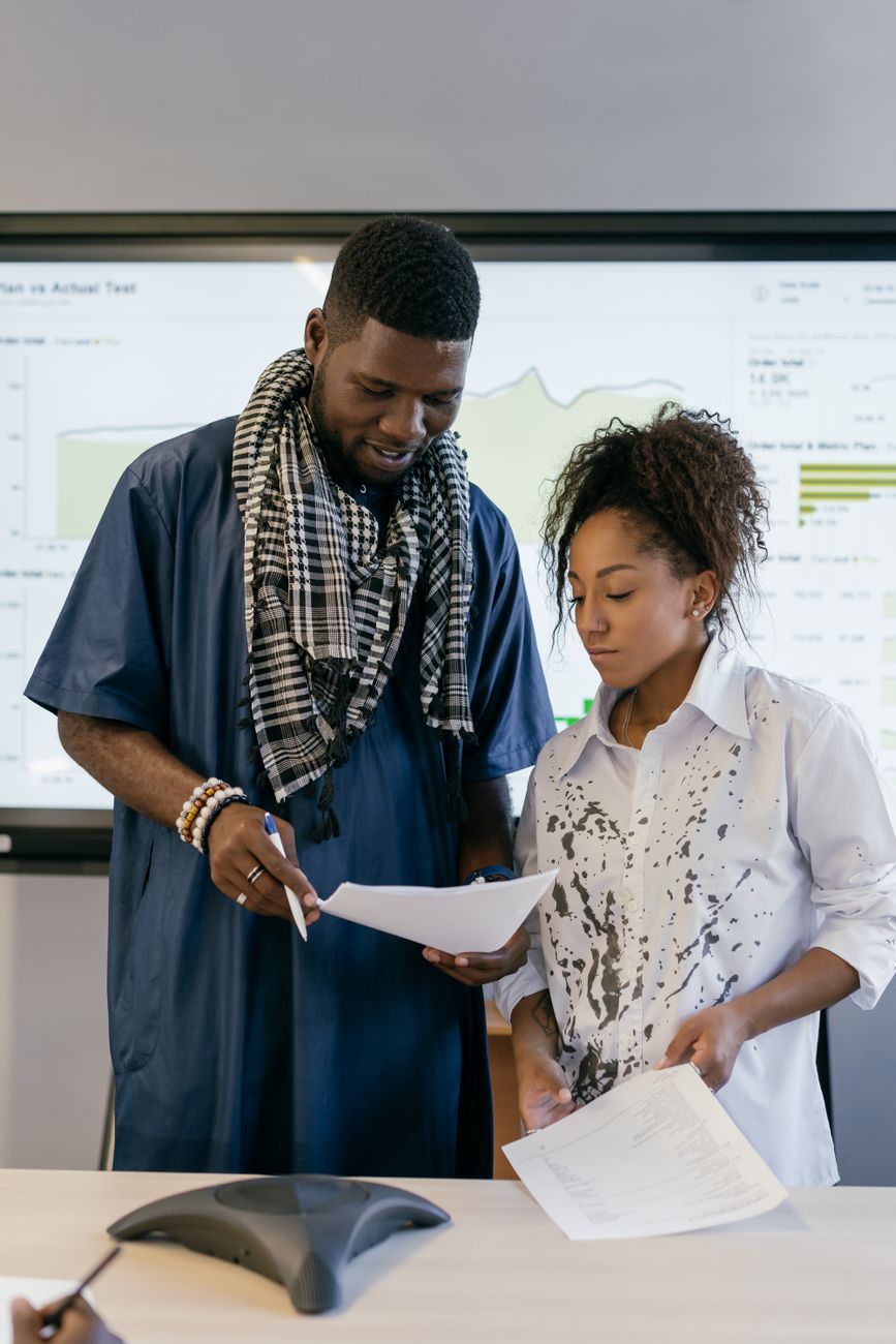 Diverse group of African creators collaborating with laptops and smartphones in a co-working space