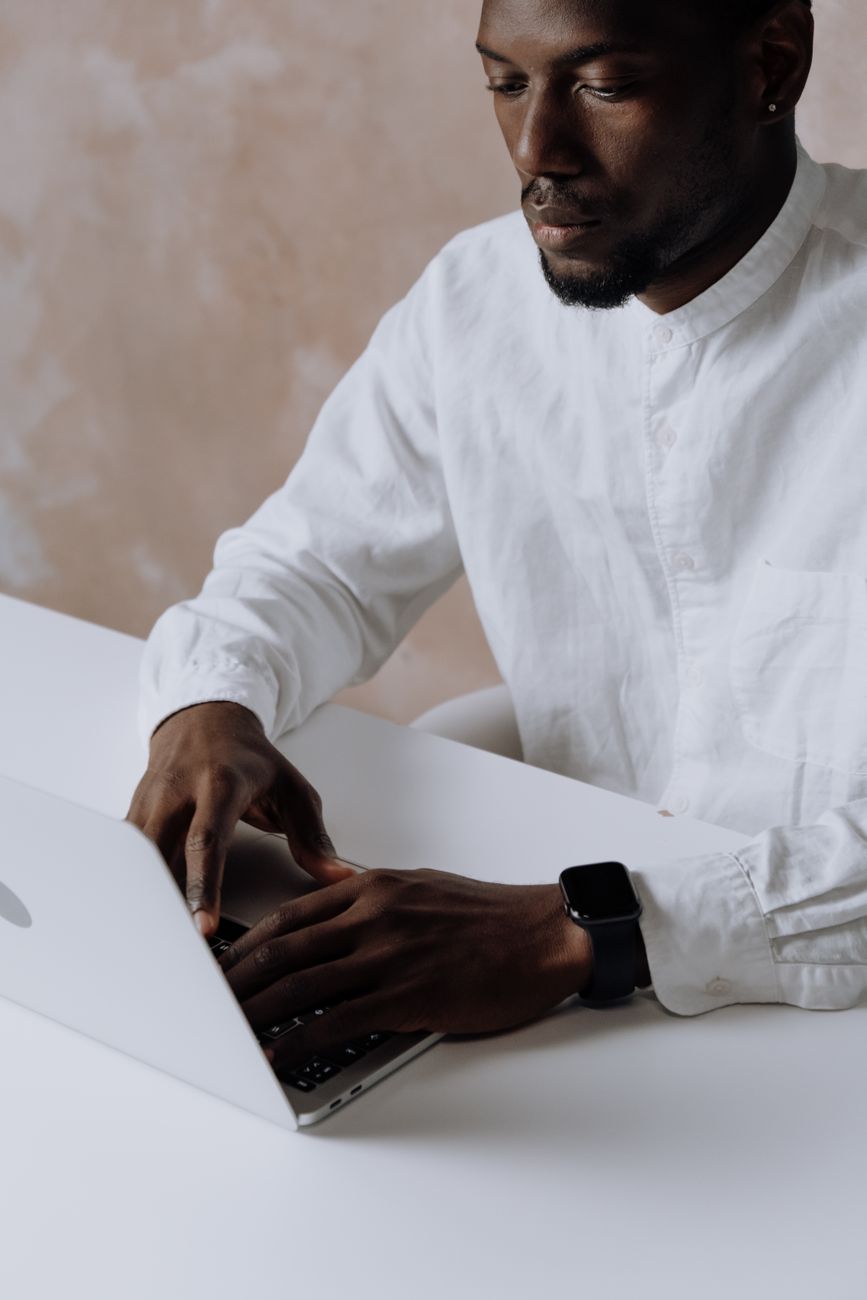 African writer typing newsletter on laptop at desk with coffee
