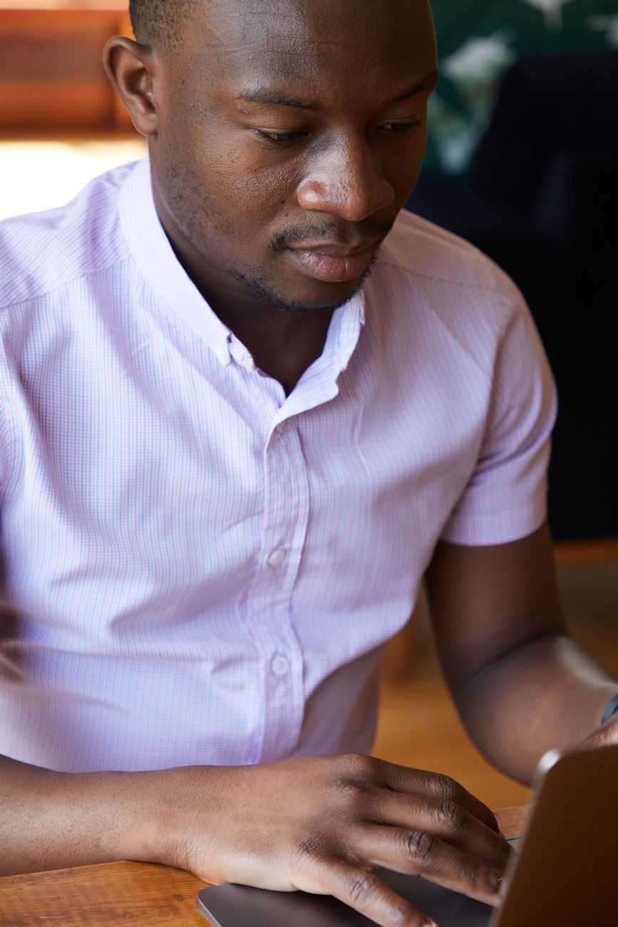 African entrepreneur browsing creator profiles on a laptop