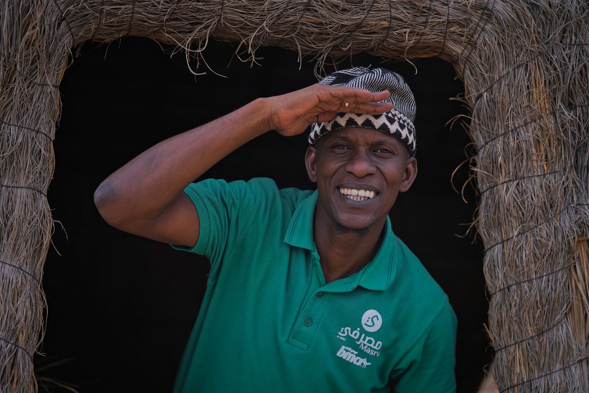 African woman warmly welcoming guests at a traditional homestead with food and drink
