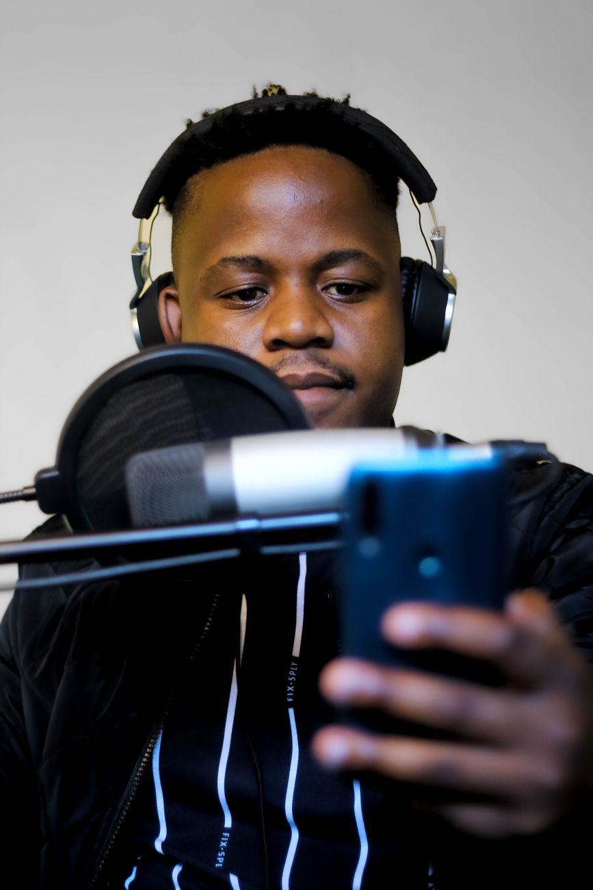 African creator recording content on a smartphone in a modern studio