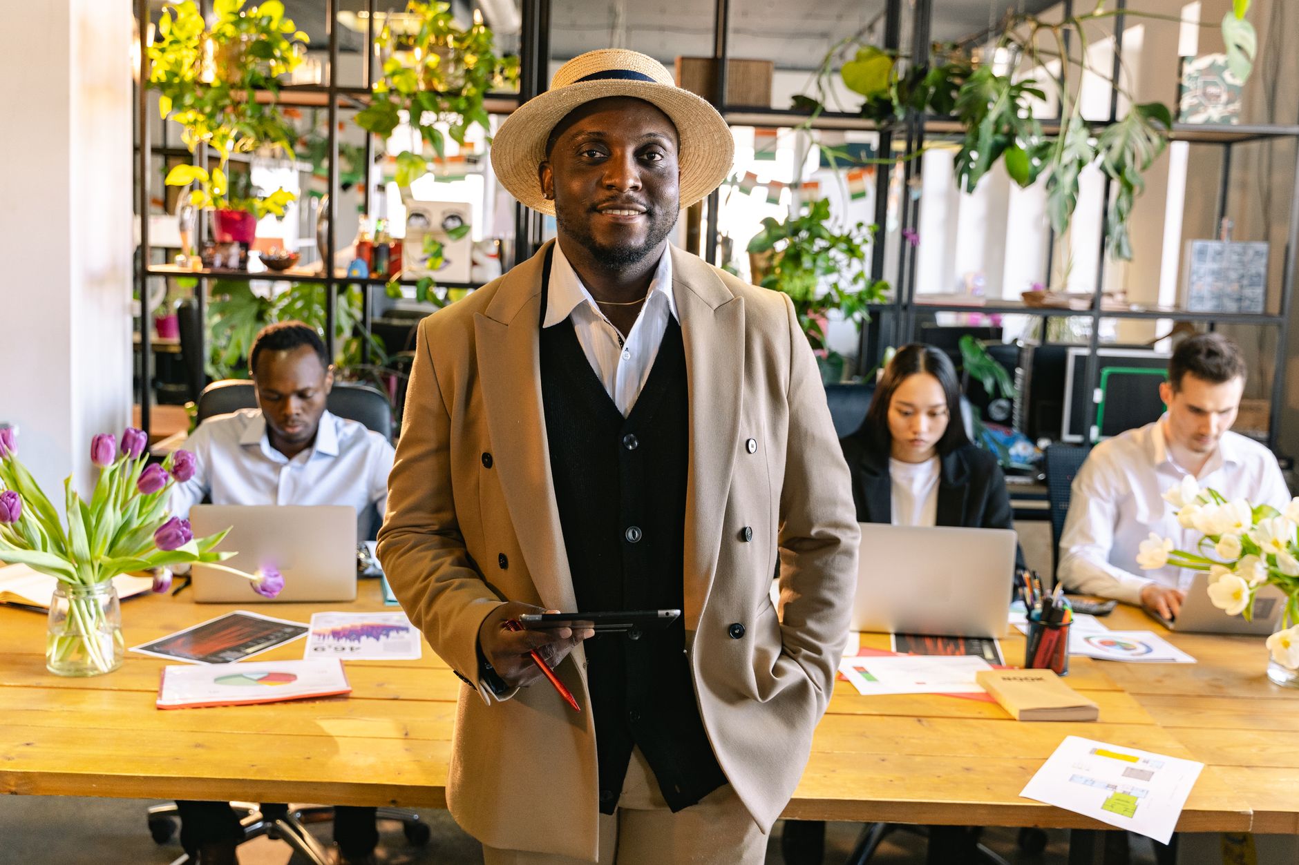 Diverse African tech entrepreneurs collaborating around a laptop in a co-working space