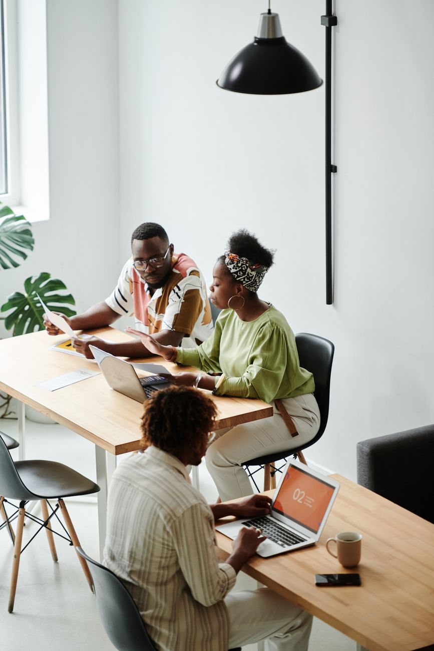 African marketing team reviewing creator profiles on laptops in a modern office