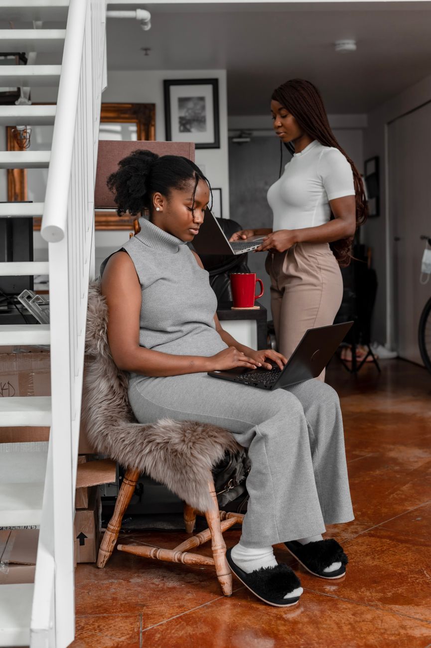 African creators collaborating on digital content with laptops and smartphones in a modern co-working space