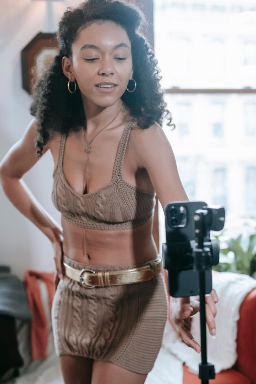 Young African content creator filming a video on a smartphone outdoors