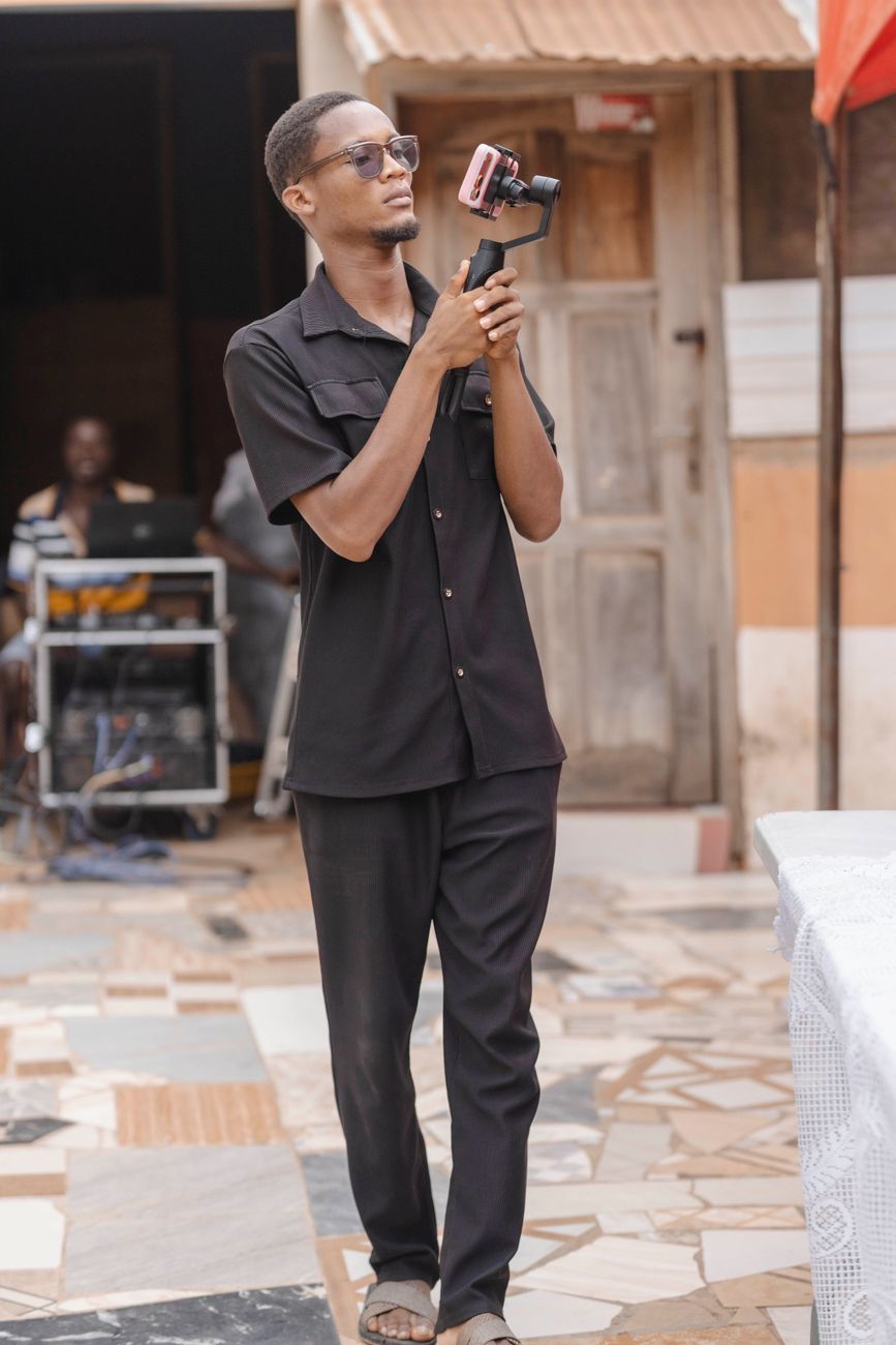 African digital creator filming traditional cultural ceremony with smartphone