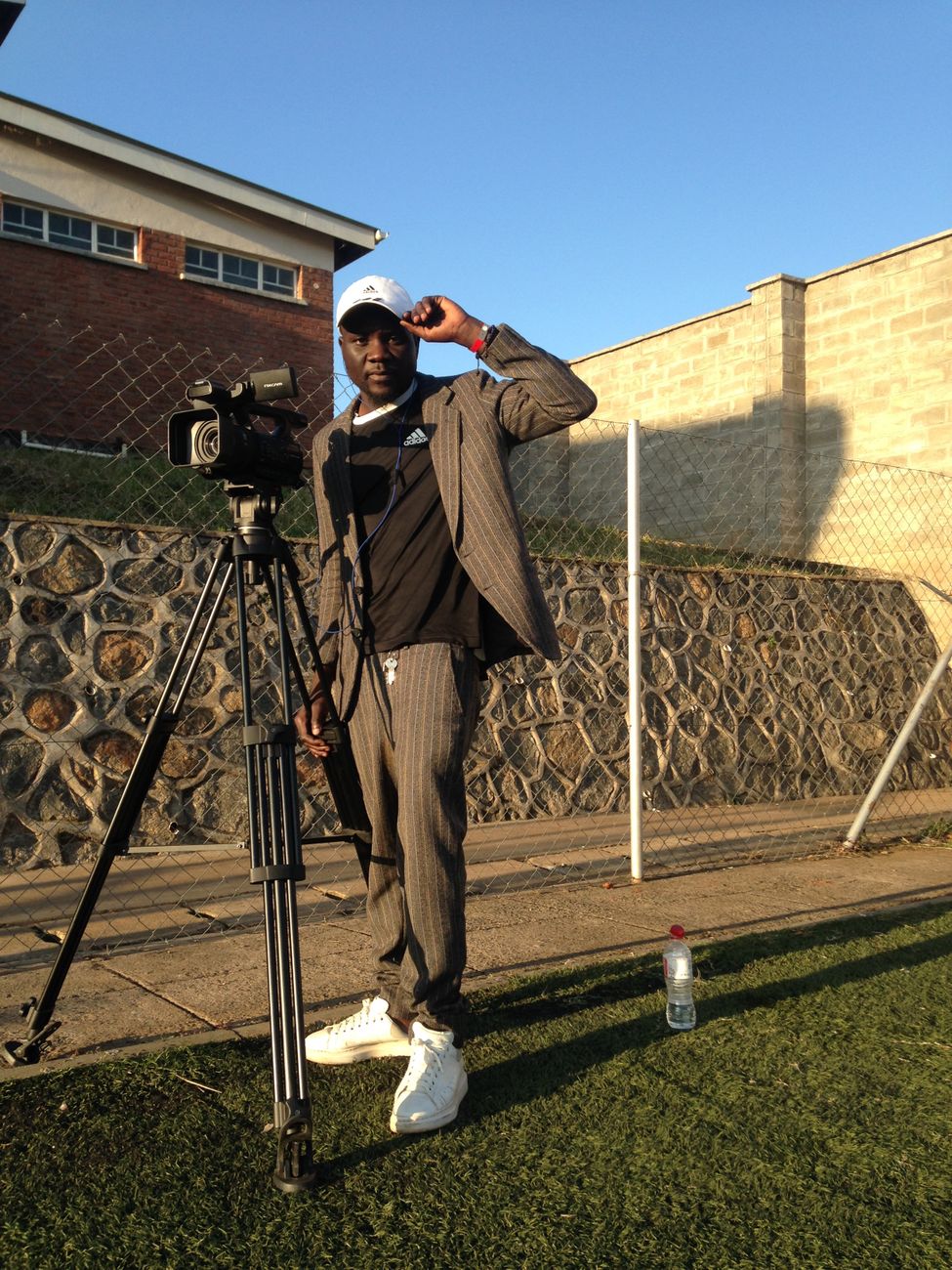 African filmmaker setting up camera equipment for cultural documentary shoot