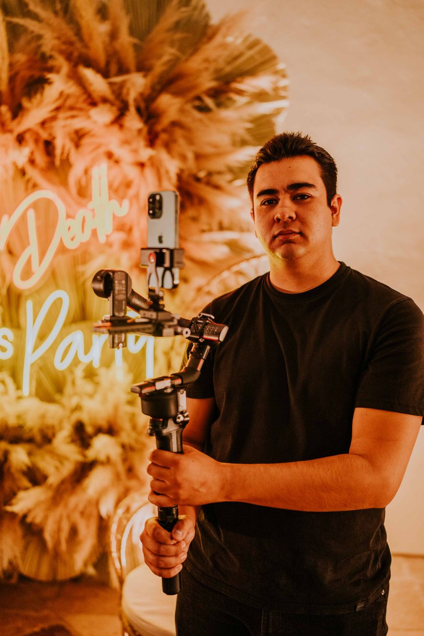 African content creator filming video at a tech event with smartphone and gimbal