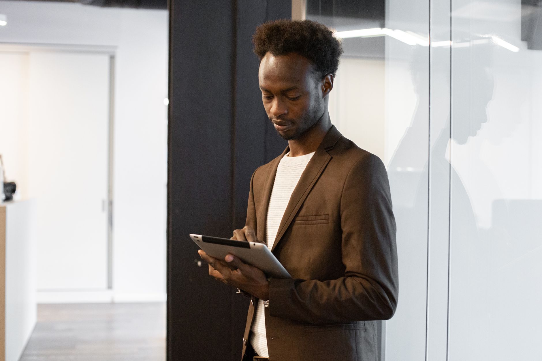 African entrepreneur using AI tools on a tablet for creative work