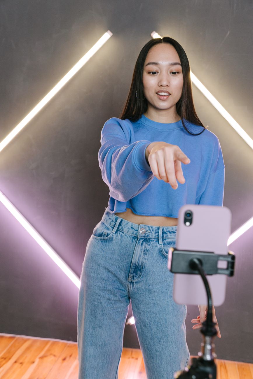 African content creator filming a video on a smartphone in a bright studio