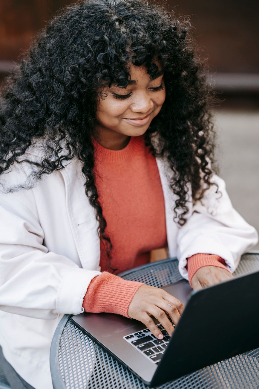 African woman working on a laptop building a digital media brand