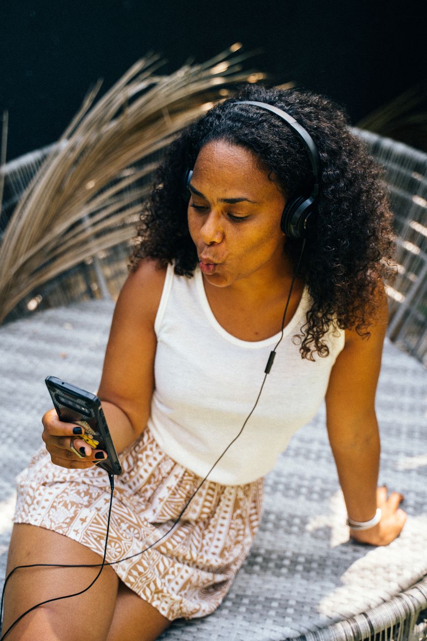 Young African woman listening to music on smartphone