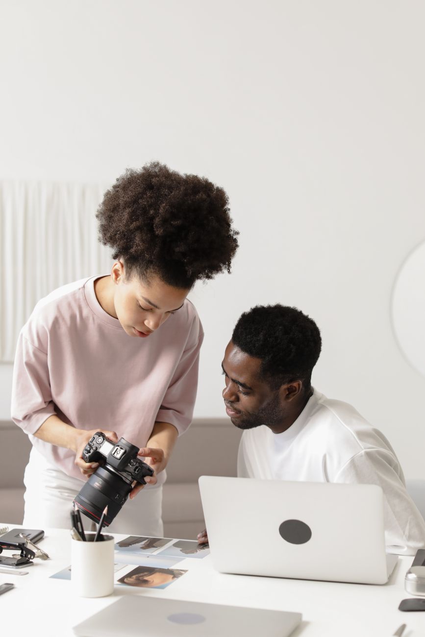 Young African entrepreneurs using smartphones and laptops for content creation