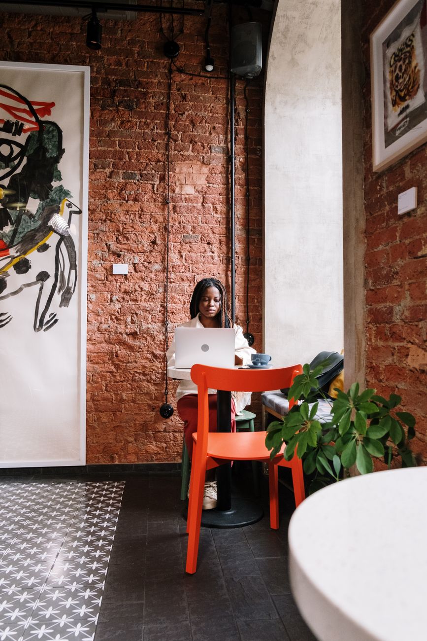 African freelancer working remotely on laptop from home office