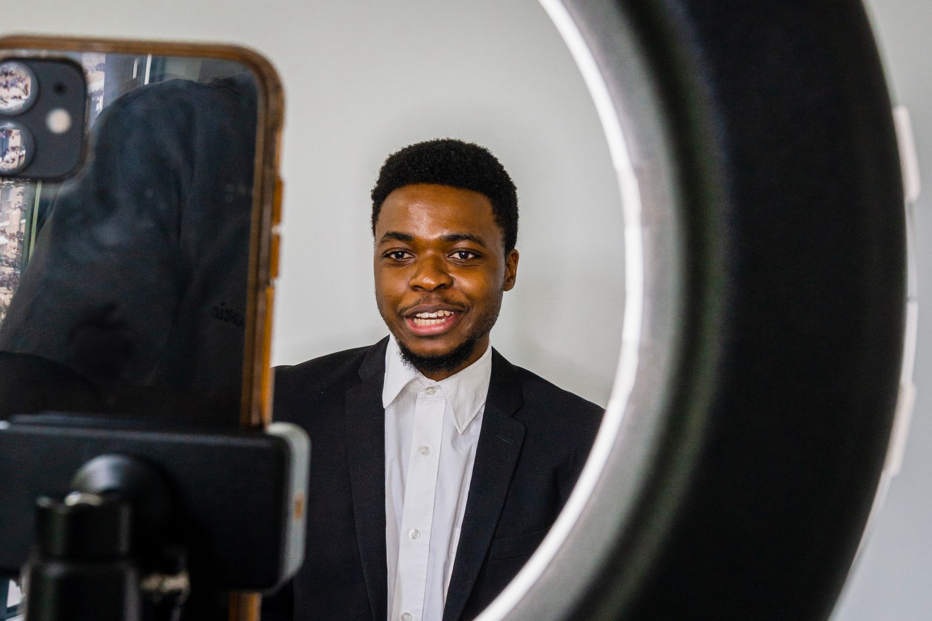 African creator filming content on a smartphone in a modern workspace
