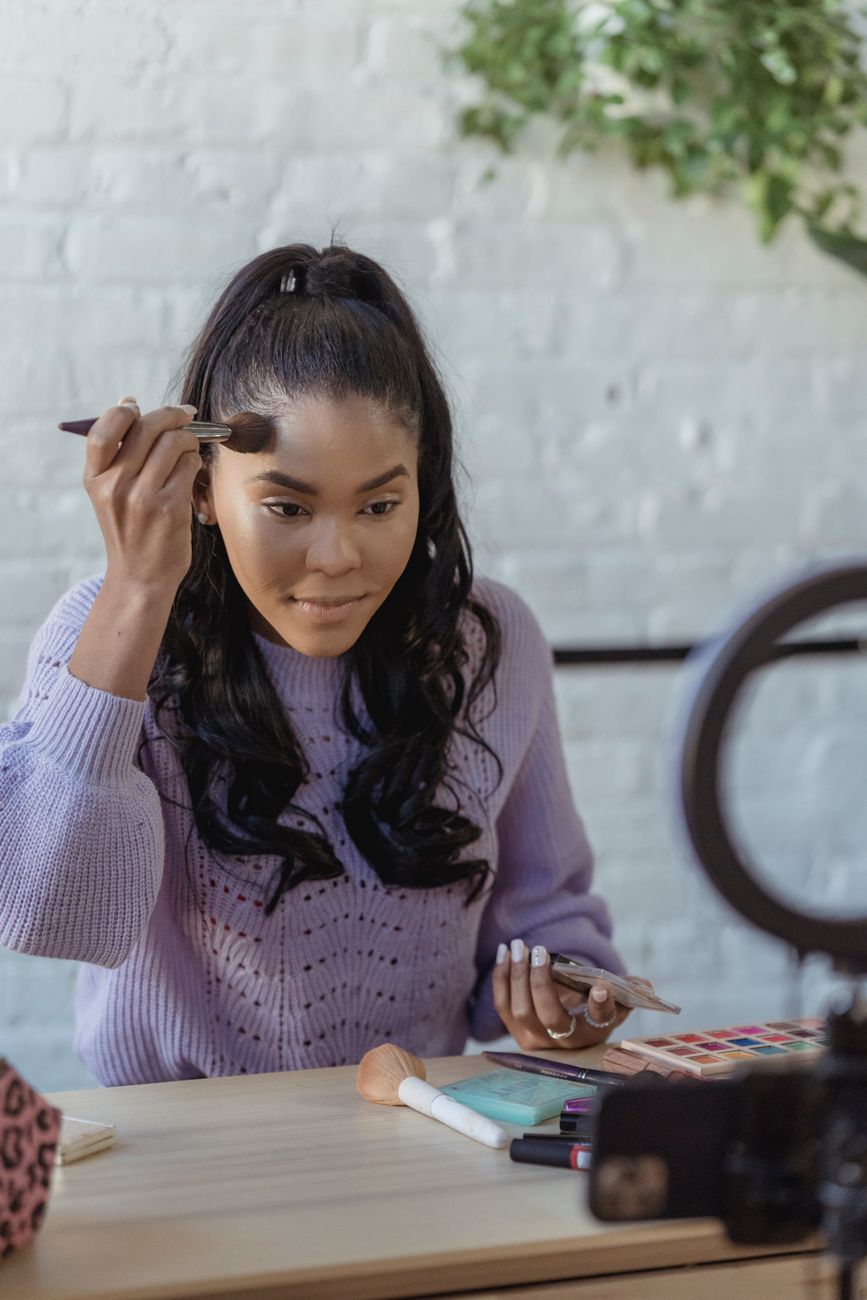 African creator filming traditional fashion content on a smartphone in a vibrant studio