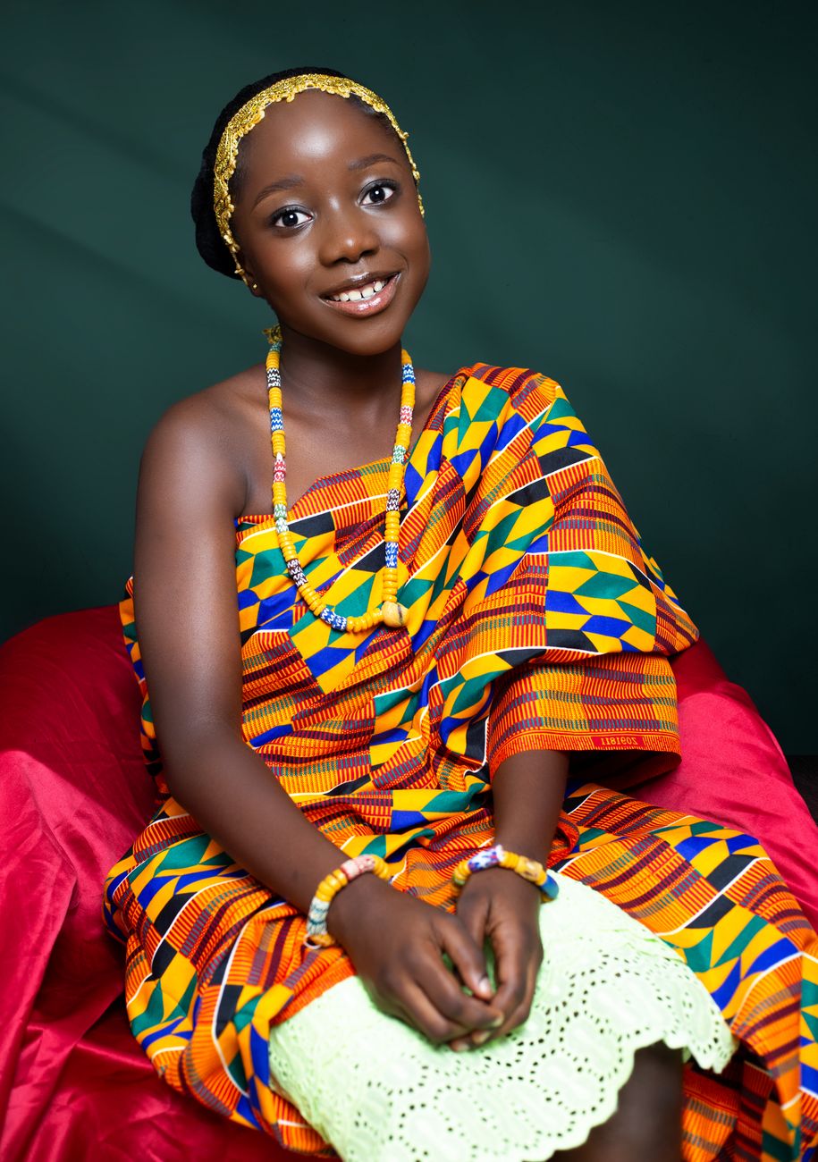 African diaspora fashion designer working on kente fabric in a modern studio