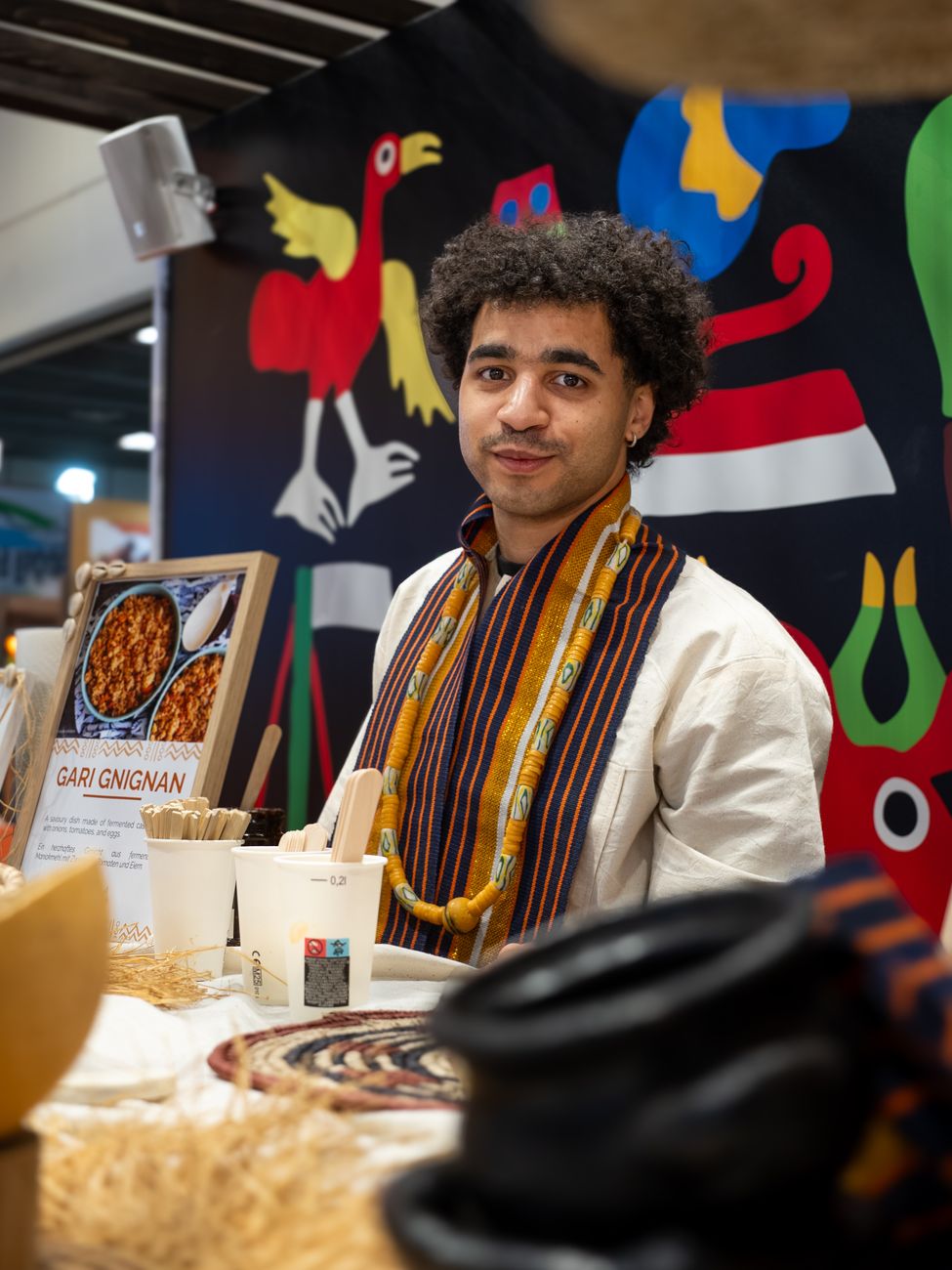 African diaspora brand founder presenting products at an international trade fair