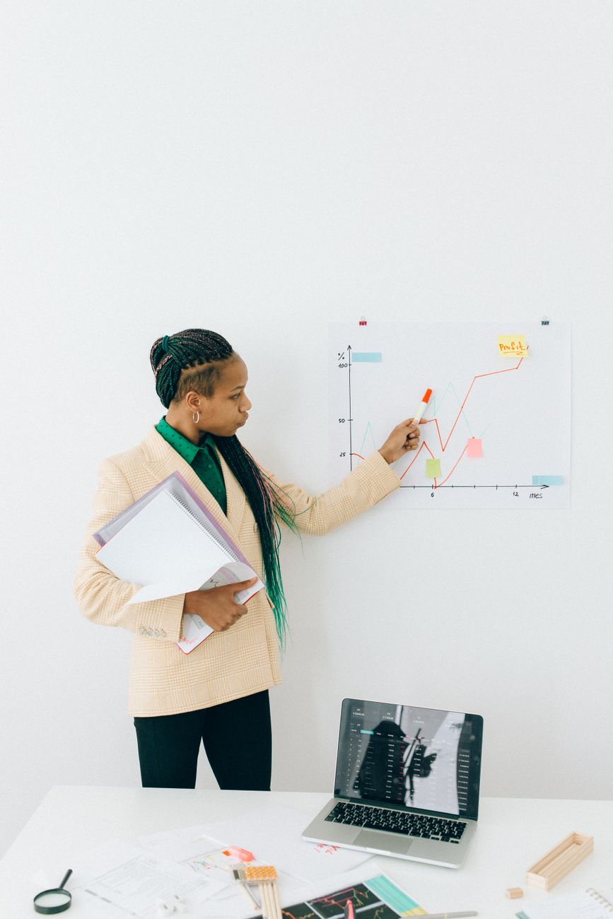 African creator working on laptop with analytics dashboard and business planning notes
