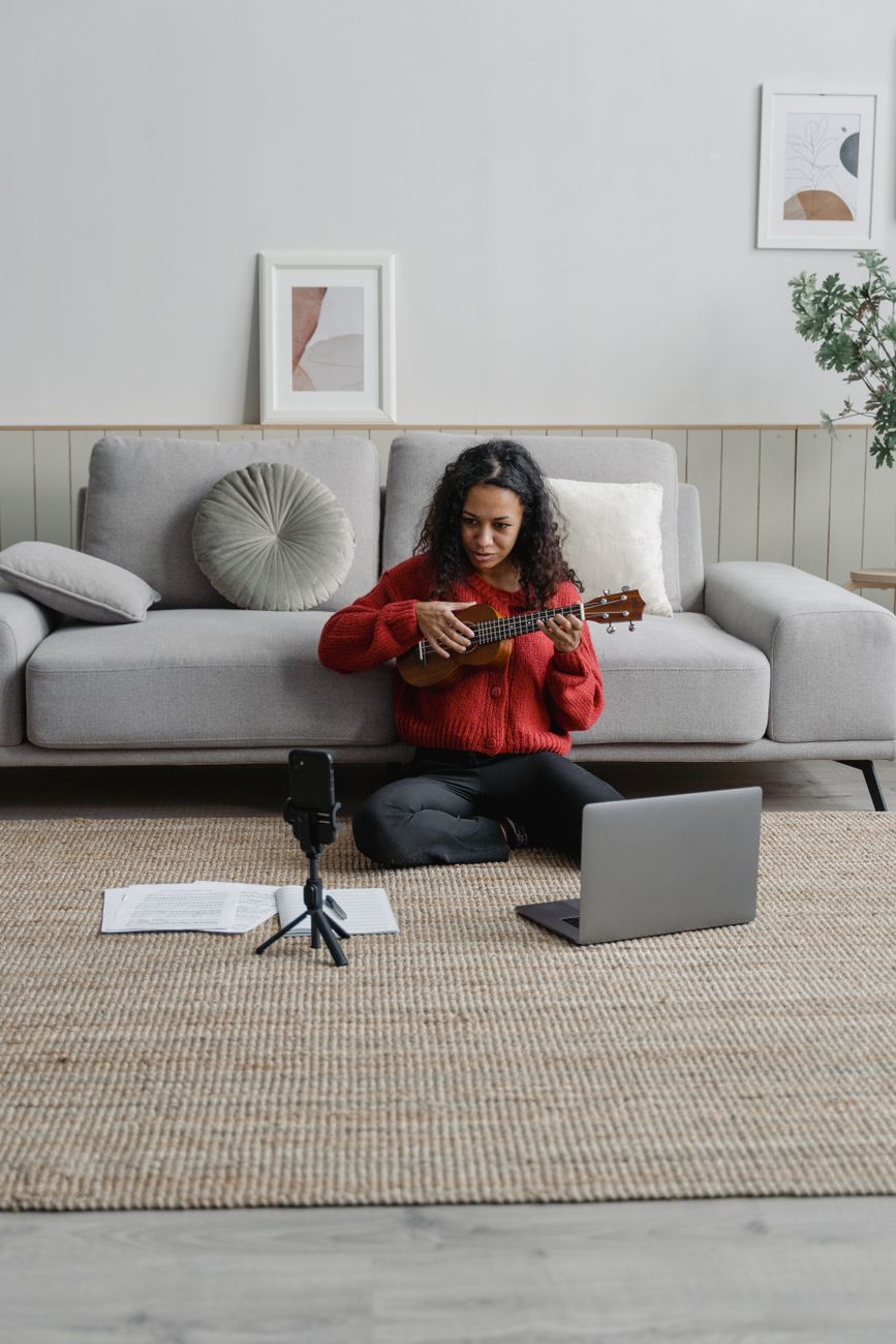 African musician uploading music to a streaming platform on a laptop