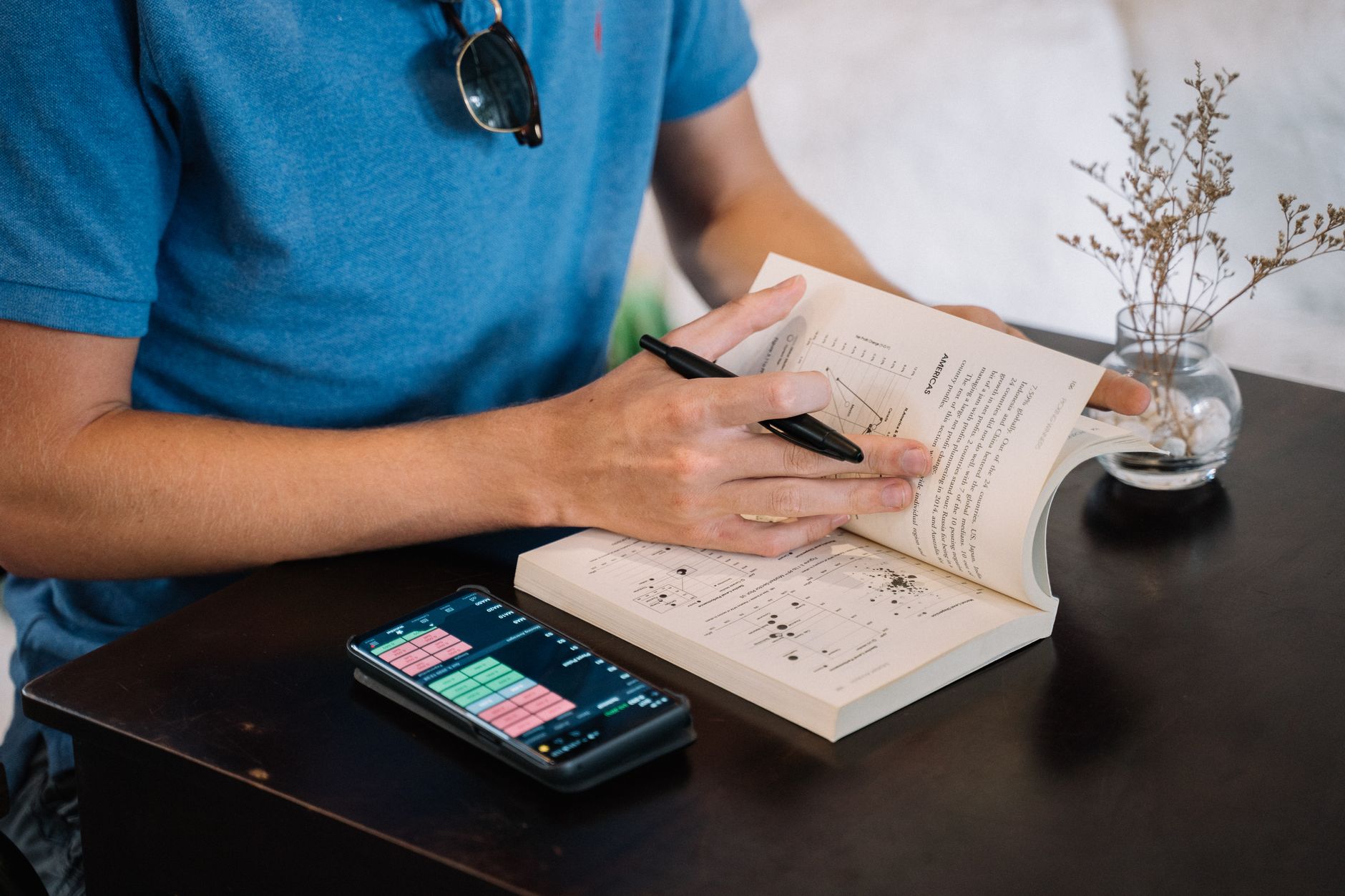 Open Bible with highlighted cross reference notes and a smartphone showing a Bible app
